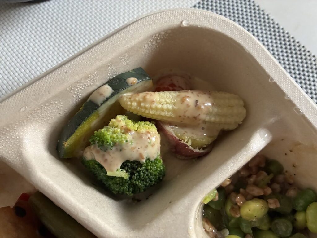 ごまドレッシングをかけたデリ弁当の温野菜サラダ